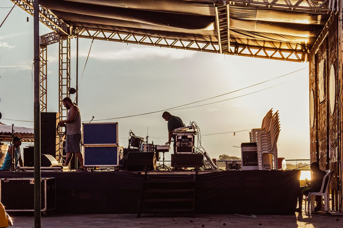 Escenario con estructura de truss, tarima y flight cases al atardecer